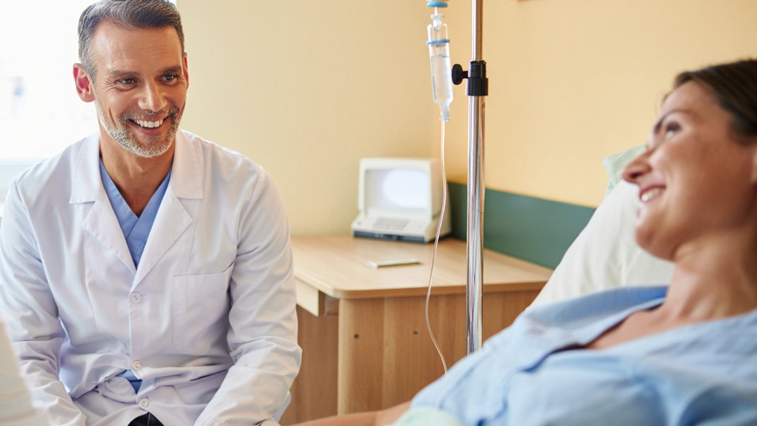 врач шутит вместе с пациентои, после успешного восстановления